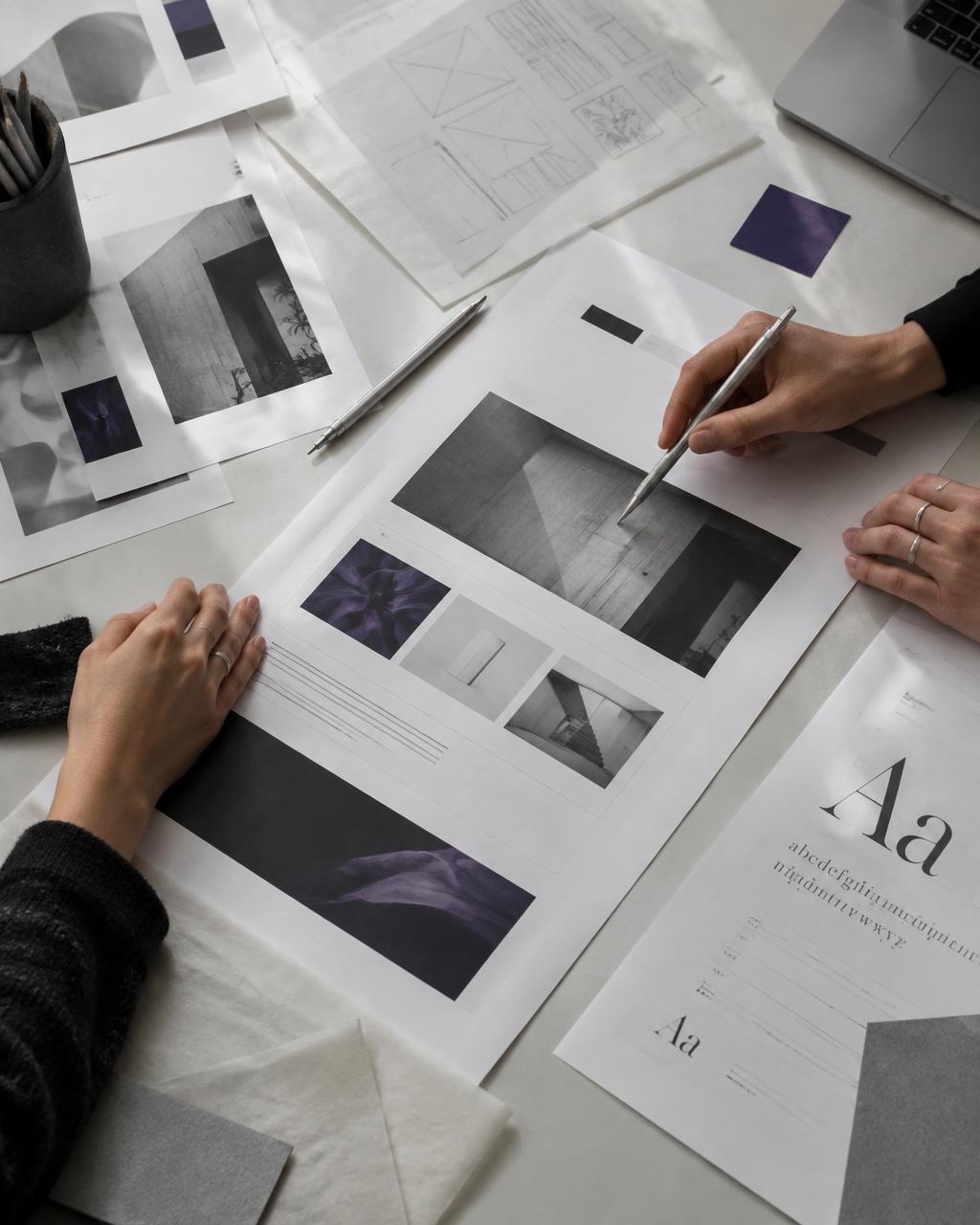 Designers reviewing print layouts together at a studio worktable